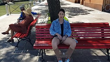 Girl masturbating on the street next to other people.